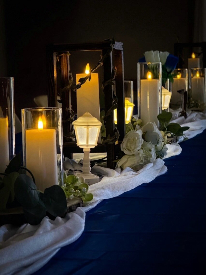 Enchanted-forest table runner with lanterns, candles and deep-blue cloth