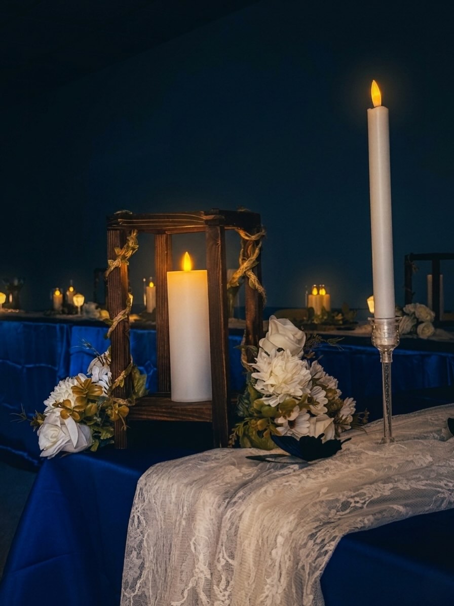 Enchanted-forest detail: wooden lantern, white roses and lace runner