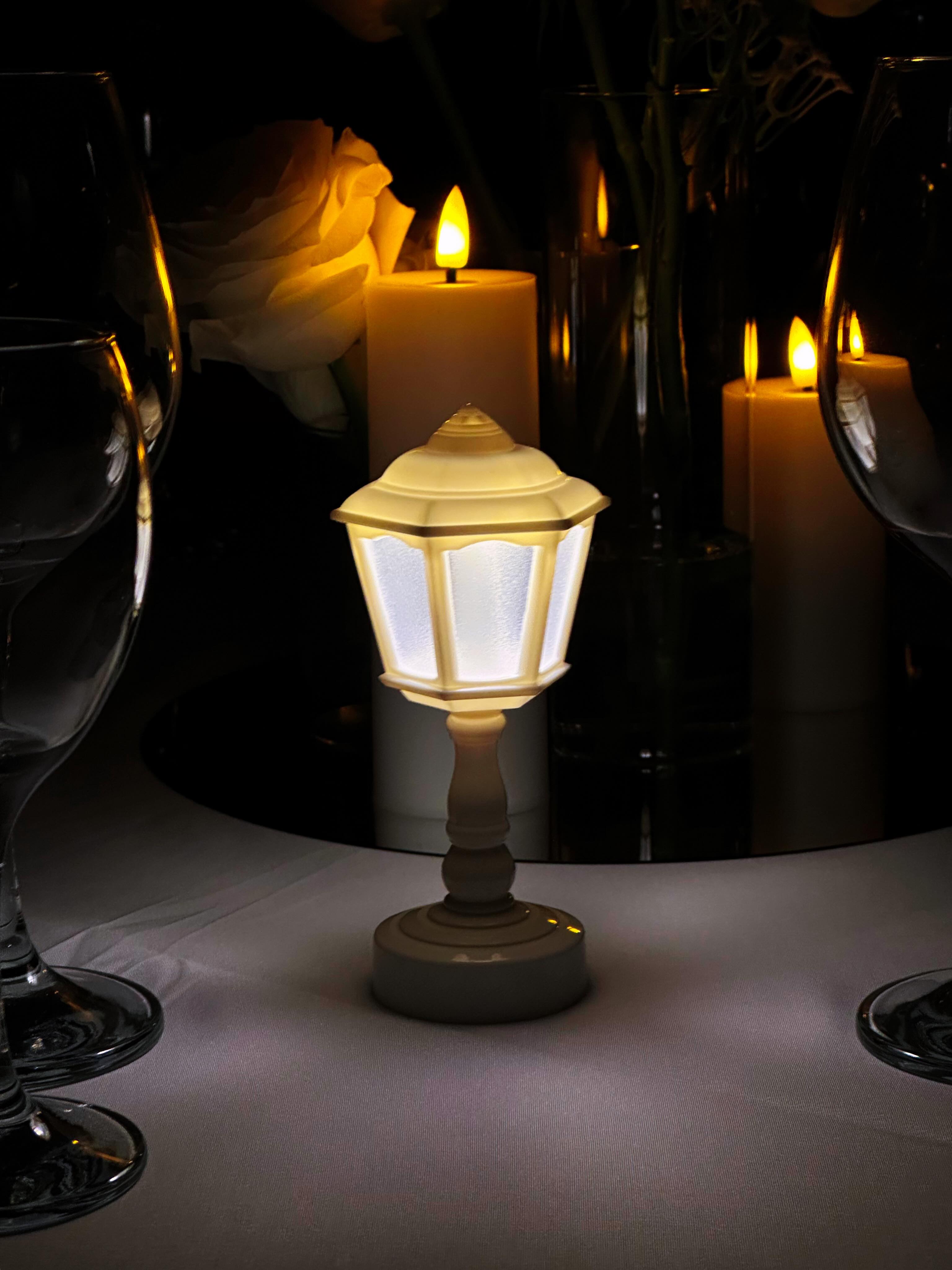 Soft candlelit ambiance with a lit lantern and a white rose
