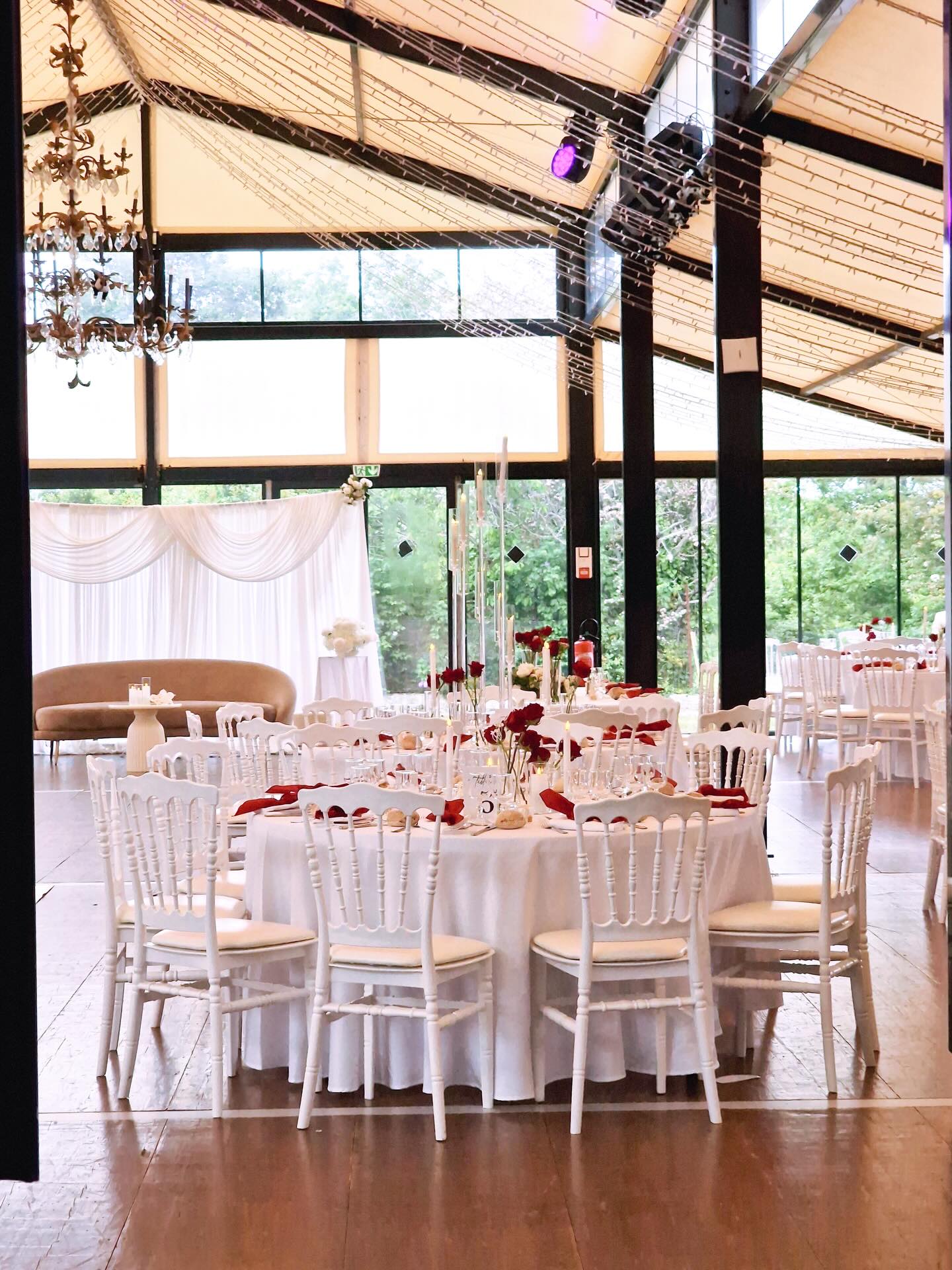 Wide reception hall with chandelier and dressed round tables