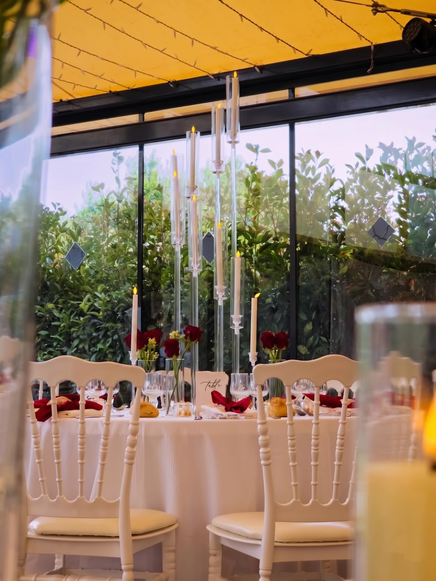 Couple's head table with tall glass candelabras and red roses